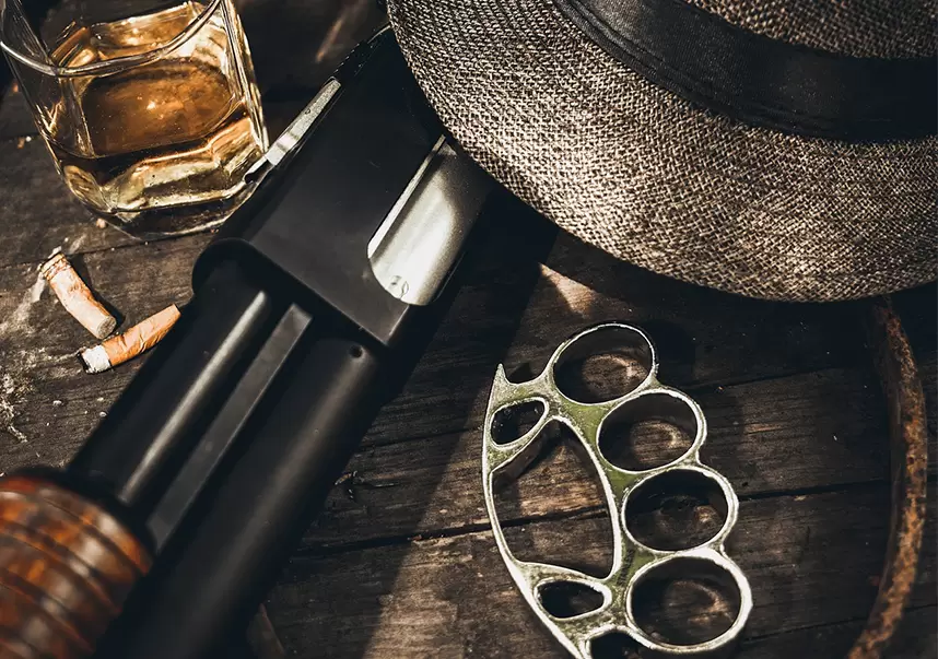 Fedora hat with brass knuckles and a weapon depicting a crime scene.